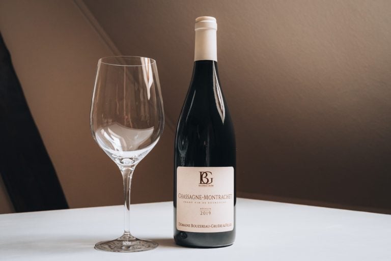 This is a bottle of wine that I bought from Cité Internationale de la Gastronomie et du Vin in Dijon. It's an unopened bottle next to a wine glass.