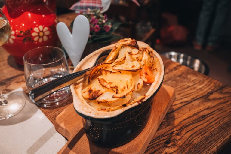 Traditional Alsatian baeckeoffe served in a ceramic dish with slow cooked meat, potatoes, and vegetables at Caveau du Vigneron in Turckheim.