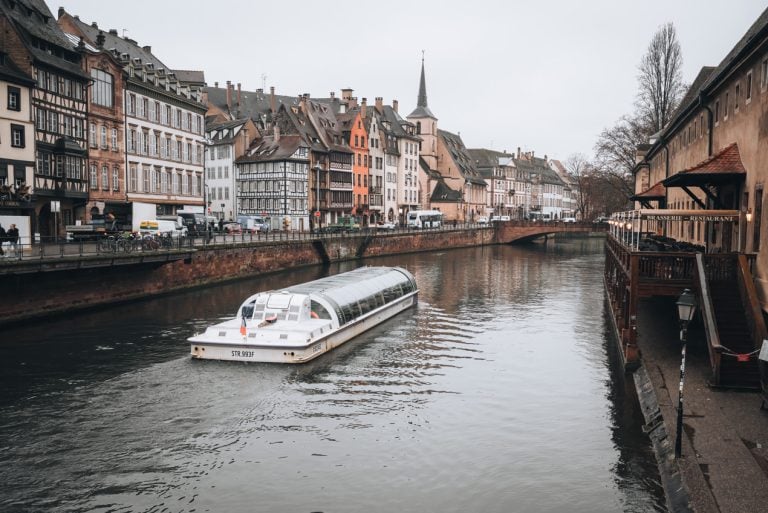 This is a Batorama Boat Tour in the Rain in Strasbourg. It's on the river sailing down. It's a covered boat.