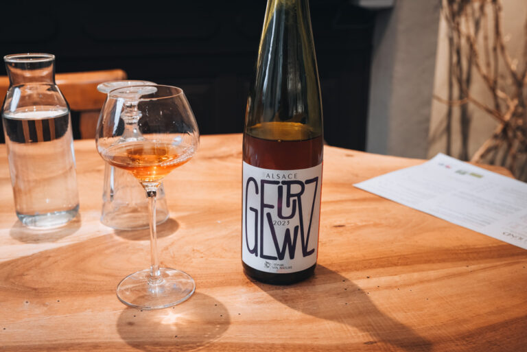 A bottle of Gewürztraminer next to a glass of Gewürztraminer from Domaine Martin Jund. This is one of the natural wines that I tried during my tasting experience.