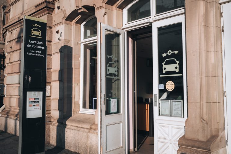 This is the entrance to where the car rentals comopanies are located at the train station in Strasbourg. There is an open door with a sticker of a car.