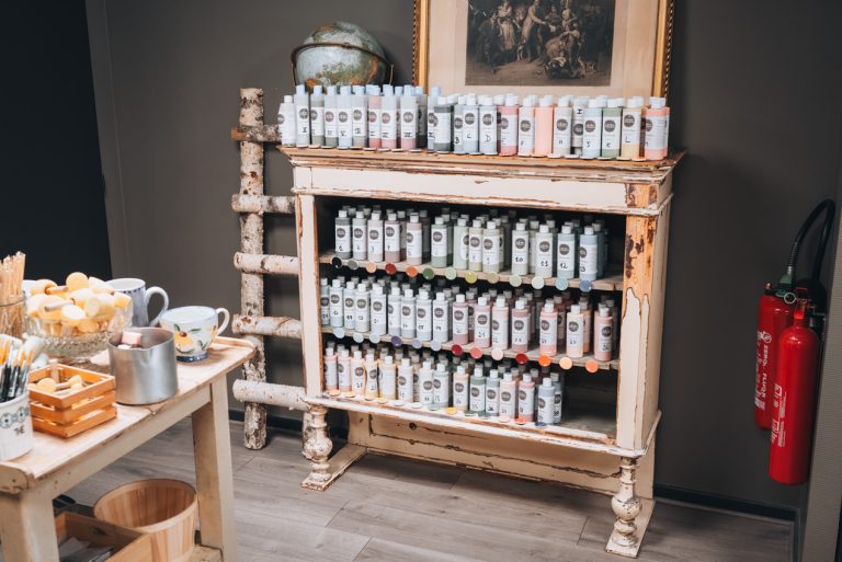 This is the shelf with the colors of paint at La Boutique des Bouleaux. There are four selves lined with tons of bottles of paint.