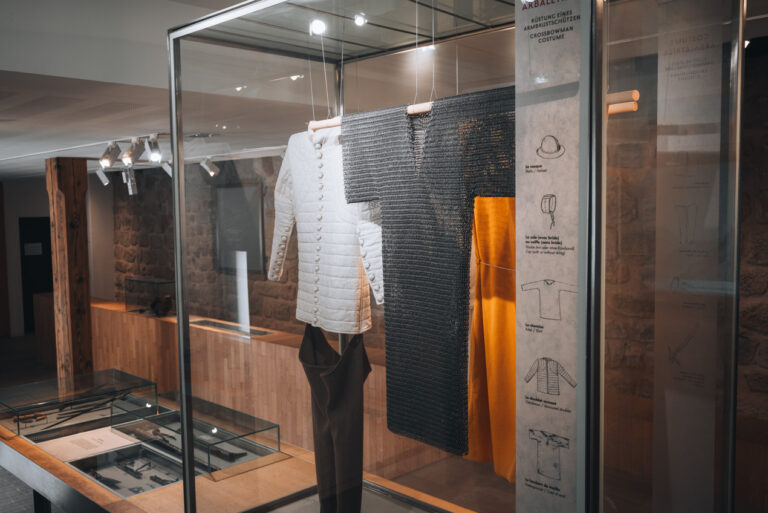 Suit of crossbowman armor displayed inside the museum at the Château du Hohlandsbourg with medieval protective gear and historical interpretation. The exhibit offers insight into life inside the fortress.