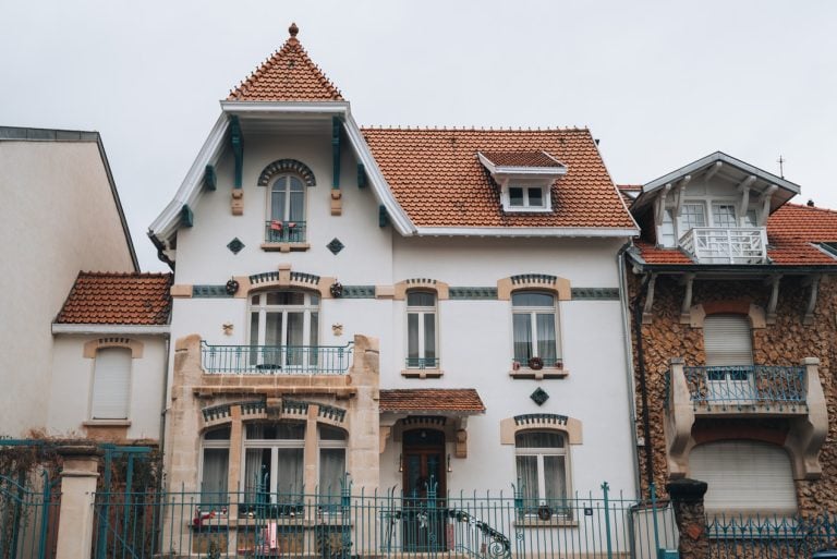 This is a house on Félix Faure. It's an example of Art Nouveau in Nancy France. It has decorative windowsills and door frames. There is also flowery ironwork on the balconies.