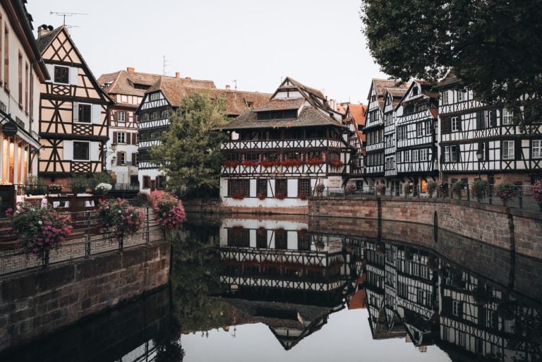 This is a photo of Strasbourg's Place Benjamin Zix. There are several white timbered houses along the canal. It's one of the best stops along this eastern France itinerary.