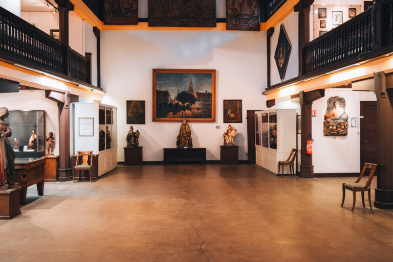 The first floor exhibits, which include paintings, a statue of Saint Theobald, and other artifacts, at the Musée des Amis de Thann.