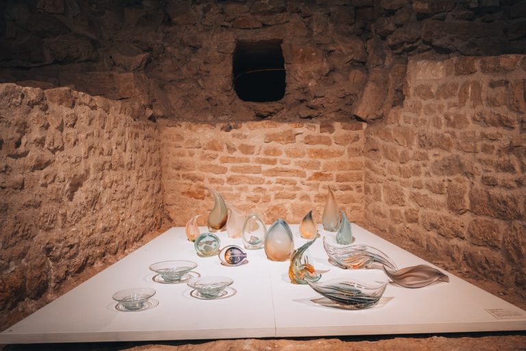 These are the former fortifications of Nancy at the Musée des Beaux Arts in Nancy. They are three stone walls and in the middle there is a large white board with glassware from the Daum factory.