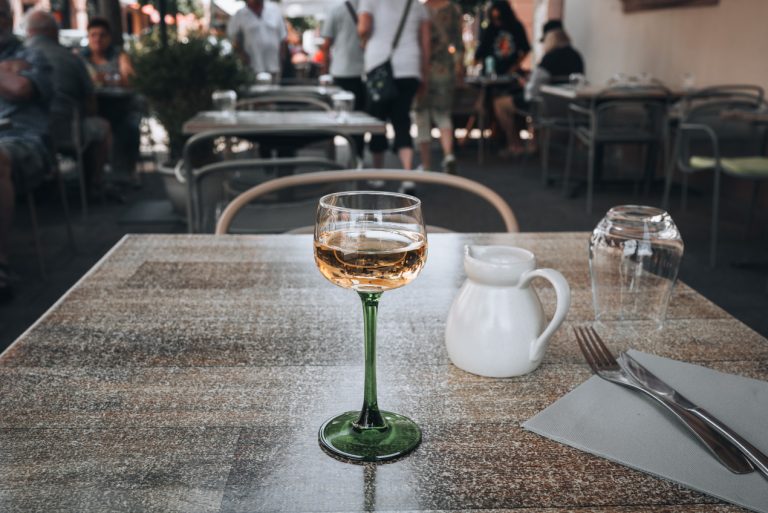 This is a glass of Sylvaner from Cave de Cleebourg that I ordered from Restaurant La Couronne in Wissembourg. It's a small wine glass sitting on a table.