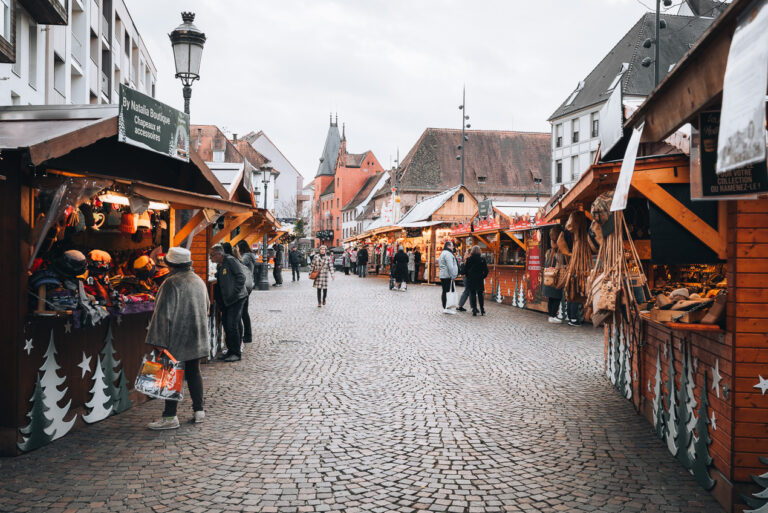 This is Grand Rue at the Haguenau Christmas Market. It's lined with wooden chalets and people are shopping.