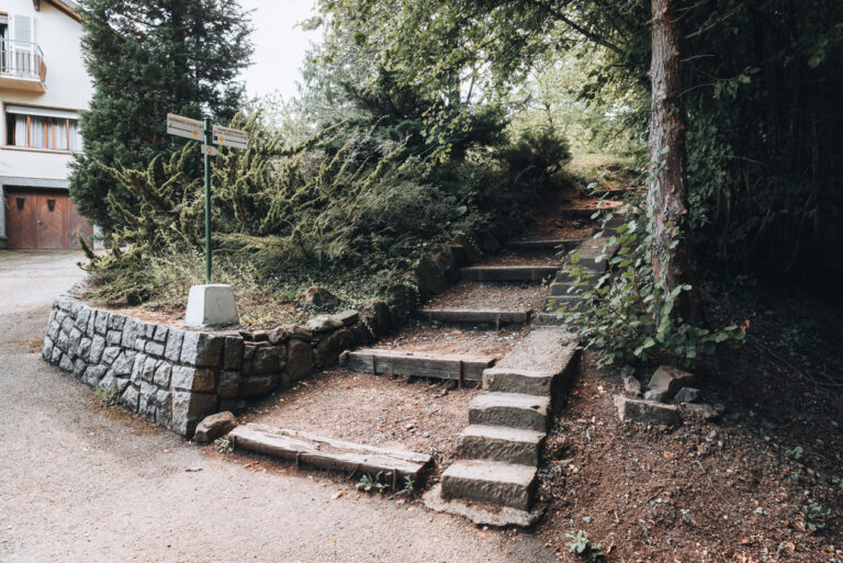 A section of the trail to Mont Saint Odile along Rue de Mont Saint Odile in Ottrott. There is a sign pointing in the direction to walk.