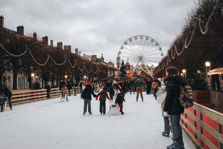 This is the Ice Skating Rink in Nancy at the Christmas Market. There are people skating and you can see of the Ferris wheel in the background.