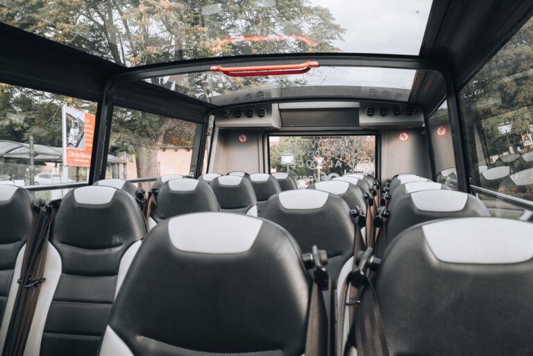 This is the inside of the Kutzig bus. There are rows of two seats and a glass roof with windows.