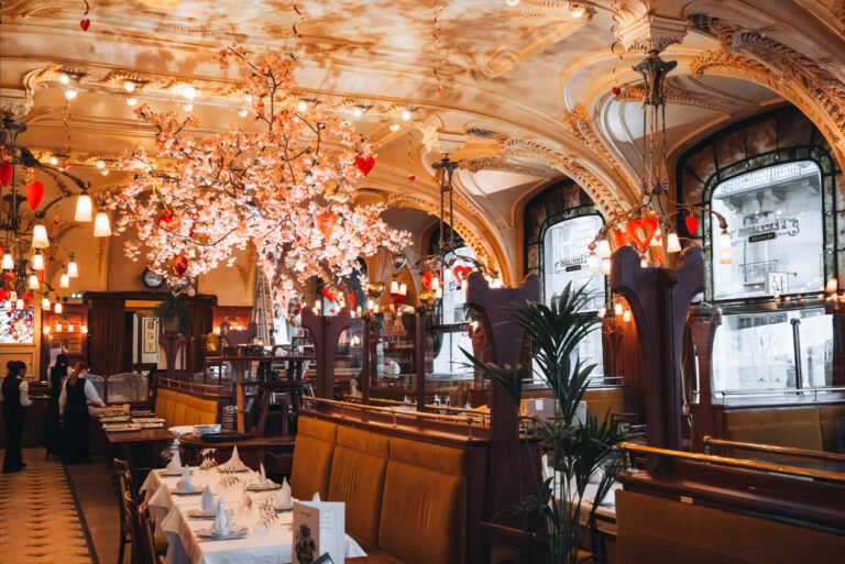 Tables and booths line the Brasserie Excelsior in Nancy. The ceiling and windows are decorated in the Art Nouveau style, which is one of the most stunning examples in France.
