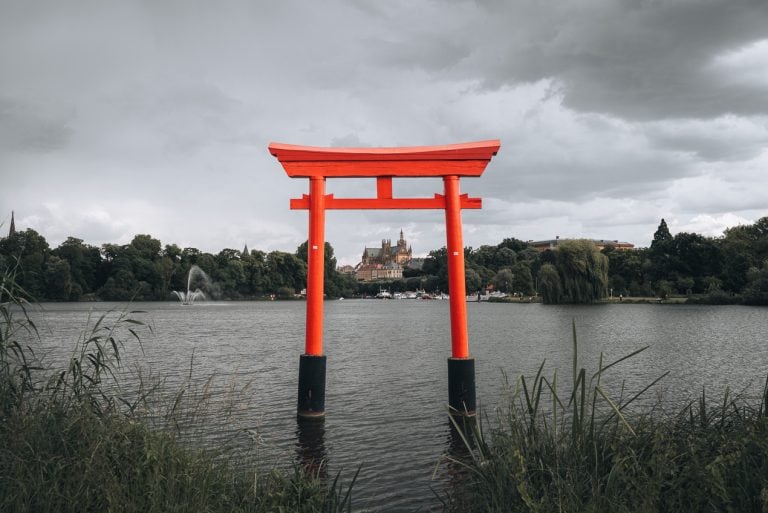 This is the Japanese Torii at Plan d’Eau de Metz. It's a large red wooden gate in the middle of the Moselle. In the center and in the distance you can see the Metz Cathedral.
