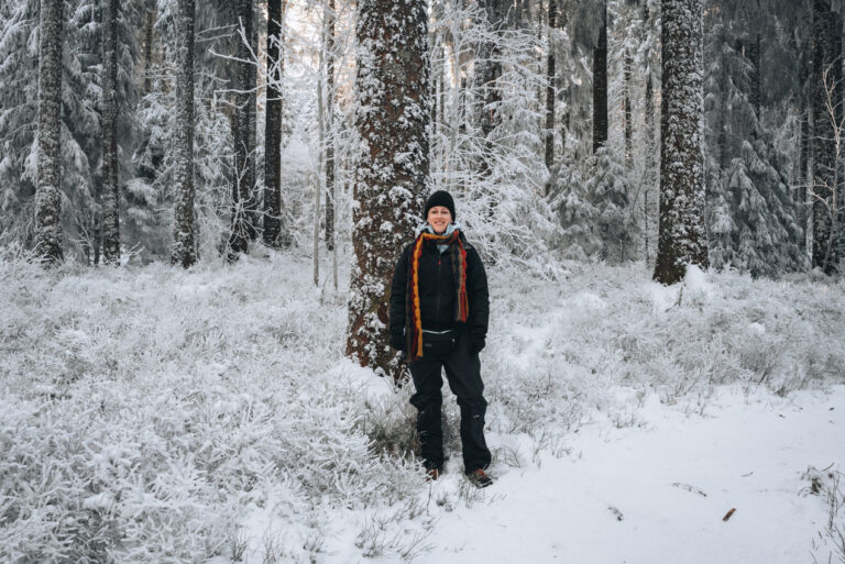Jen Ciesielski dressed in snow gear standing on a snowshoeing trail in Champ du Feu.