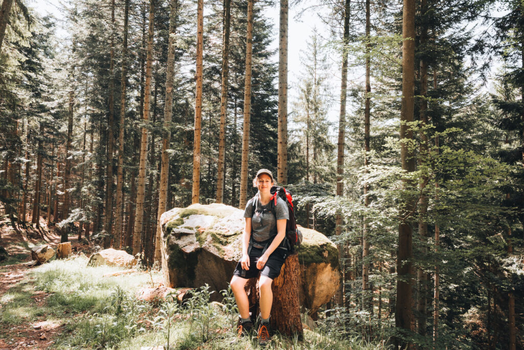 Jen Ciesielski dressed in shorts and a t-shirt and carrying her backpack while hiking in Alsace.