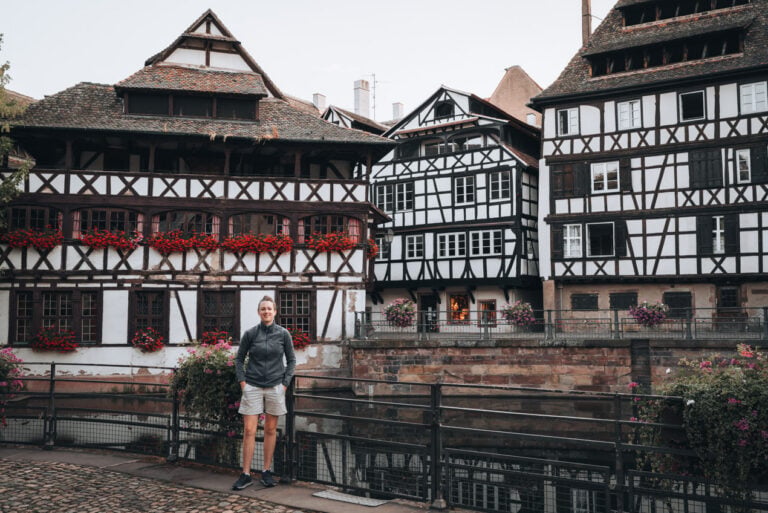 Jen Ciesielski standing in front of half-timbered houses in the La Petite France neighbourhood of Strasbourg. This area makes you wonder if Strasbourg is in Germany or France.