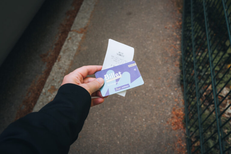 Jen holding two pieces of paper. One is a receipt for the shuttle bus and the other is the ticket for the shuttle bus that goes to the Haut-Koenigsbourg Castle.