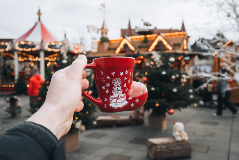 Jen holding her Colmar Christmas Mug. It's a red boot mug with Christmas symbols in white.
