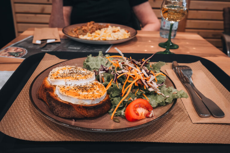 A vegetable filled salad next to a toasted baguette topped with melted goat cheese. This is what Jen ate at the 757 restaurant.