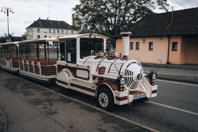 This is the Little Tourist Train in Ribeauvillé. It's a small while train that is parked and getting ready to leave for a tour.