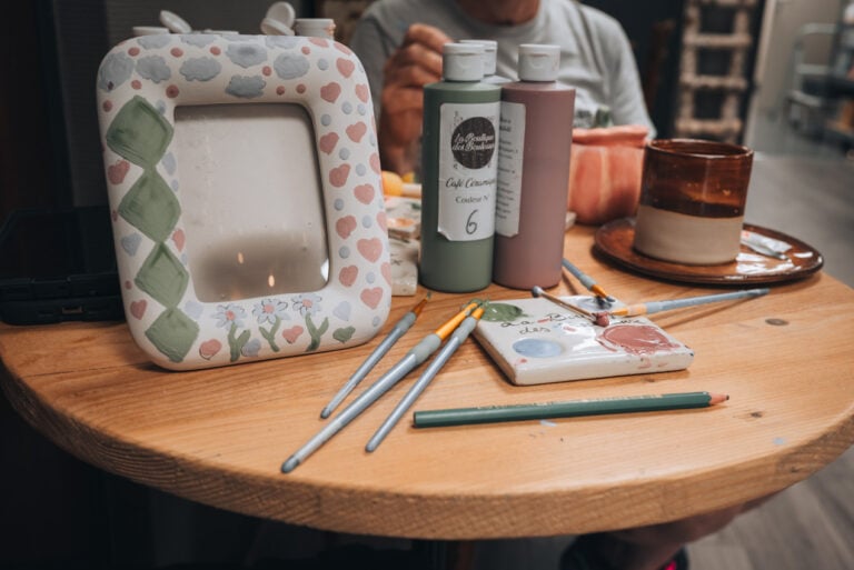 My hand-painted ceramic picture frame on a wooden table inside La Boutique des Bouleaux in Strasbourg.