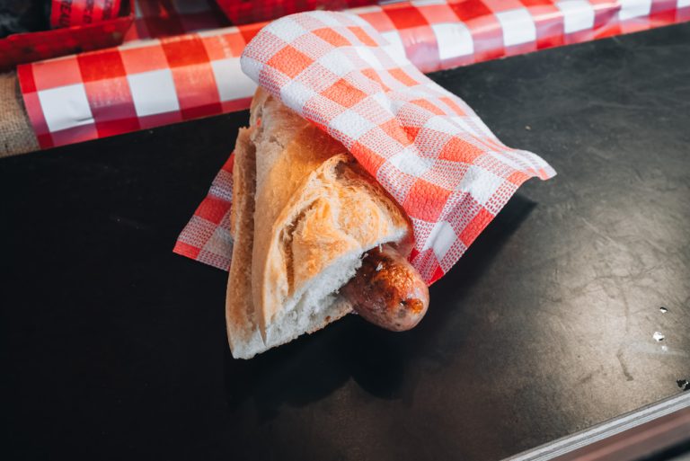 This is my sausage sandwich from the Christmas market. The sausage is in a baguette and wrapped in a napkin. 