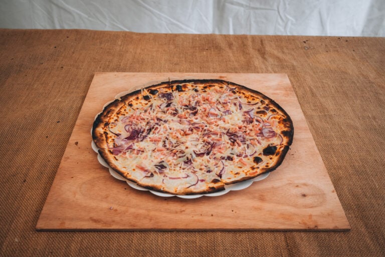 The Tarte Flambée that was made in front of me at the Christmas Market in Neuf Brisach. It's round, topped with cheese, lardons, and a cream sauce.