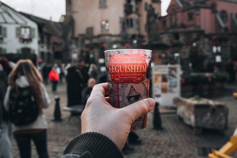 This is a photo of me holding a cup of mulled wine in Eguisheim. The glass says the name of the town.