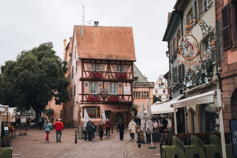 This is Grand Rue Colmar's Old Town. It's a cobbled street with a half-timbered house at the end. Then, on the right, there is the Hotel Saint Martin.