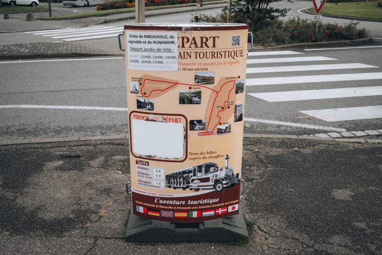 This is a photo of the operating hours for the tourist train in Ribeauvillé. It's only open from May to September and much of the information is covered with other signs and changes.