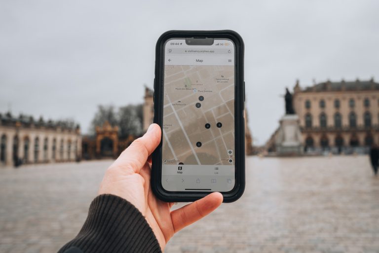 This is a photo my hand holding my phone, which has a map of the Parcours Art Nouveau on it. It dows the different stops and they are numbered.