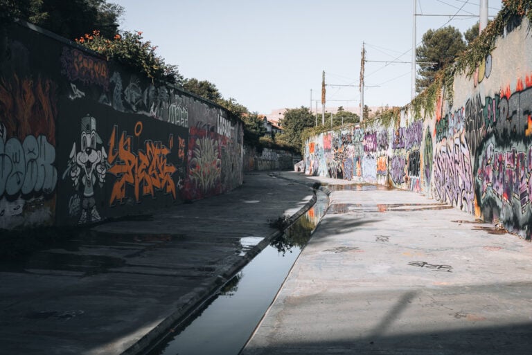 This is Quai de Verdanson. It's a long tunnel with a small canal full of water running down the center. On either side there are tall concrete walls covered in graffiti and urban art.