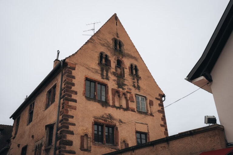 The Romanesque House in Obernai a large medieval stone building with small windows and a steep roof. It is one of the historic stops along the Old Town Circuit walking route through the town.