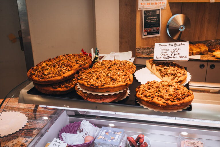 Tray of freshly baked Ropfkueche pastry displayed at Rohmer Bakery in Rosheim. The traditional Alsatian treat sits on a counter inside a rustic bakery setting with warm lighting and handmade local baked goods.