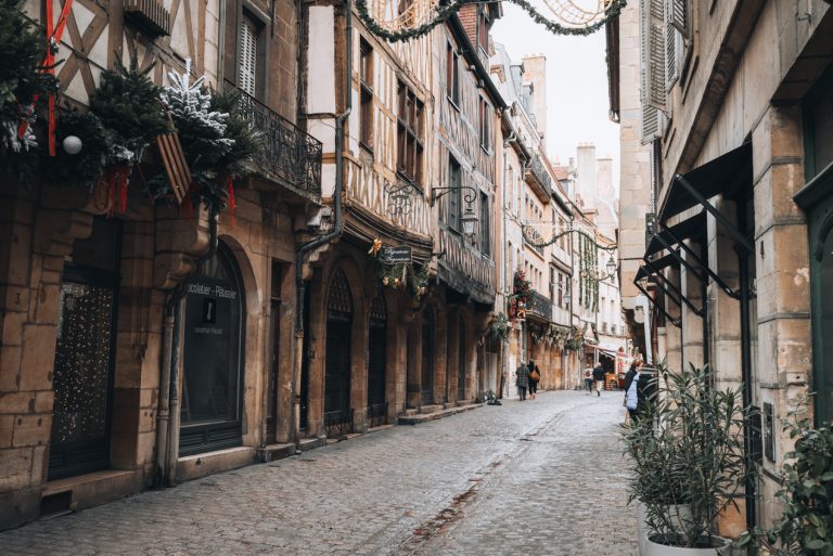 This is Rue Verrerie in Dijon. It is one of the most photogenic streets. It's made of cobblestone and lined with half-timbered houses. And since I took this photo in winter there are Christmas decorations.