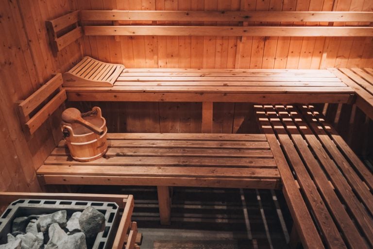 This is the sauna room at Taaka Beer Spa. There are two levels of wooden benches and hot stones in the corner. There's also a bucket of water to pour on the stones.