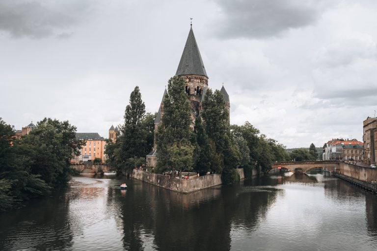This is the Temple Neuf in Metz. It's a church in the middle of the Moselle flanked by two bridges and surrounded by trees. It's free to visit.