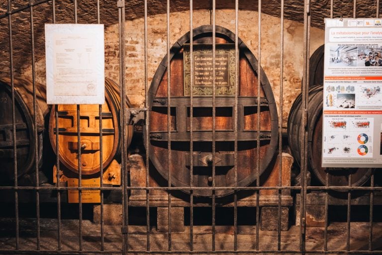 This is the oldest barrel of white wine at the Cave Historique des Hospices de Strasbourg. It's a wooden barrel with a sign from when it was made and it's behind metal bars.