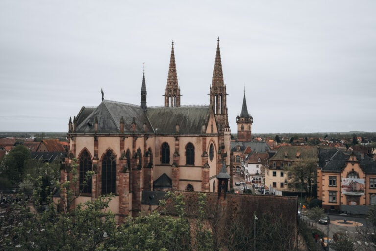 Aerial view of Saints Peter and Paul Church rising above the rooftops of Obernai’s historic center. The large neo Gothic church dominates the skyline and is one of the most recognizable landmarks among the many things to do in Obernai France.