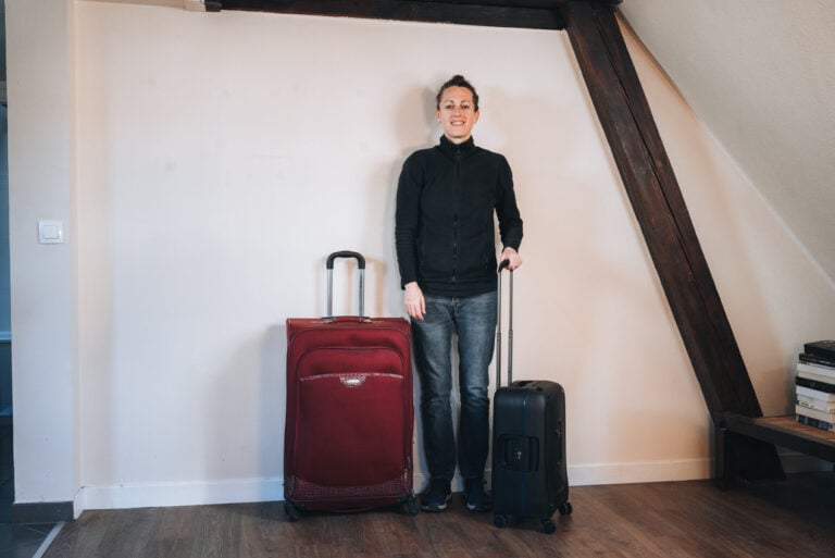 Jen Ciesielski standing in her new apartment in Strasbourg with her luggage. Strasbourg is one of the best places to live in France for expats.