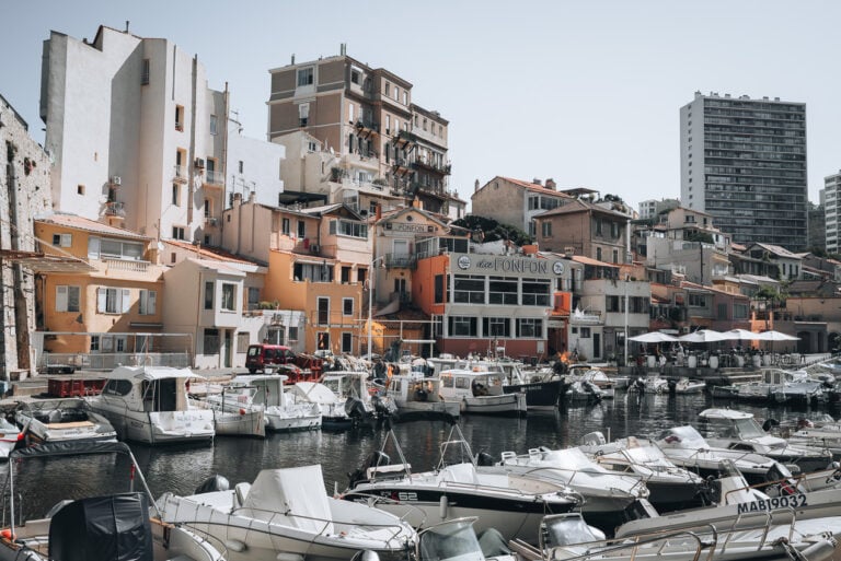 This is Vallon des Auffes. It's a small harbor filled with boats and surrounded by colorful residential buildings.