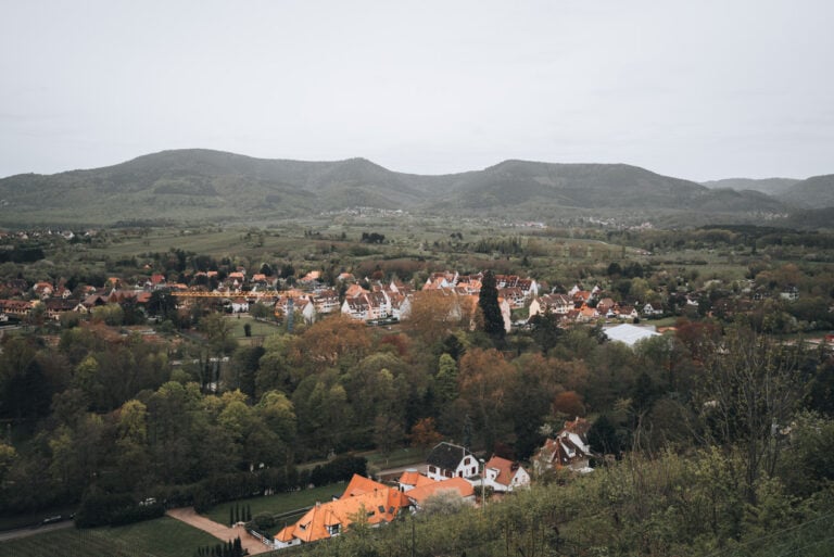 Panoramic view from Mont National overlooking the red tiled rooftops of Obernai with the Vosges mountains stretching across the horizon. This scenic viewpoint is a popular stop for travelers exploring Obernai France.