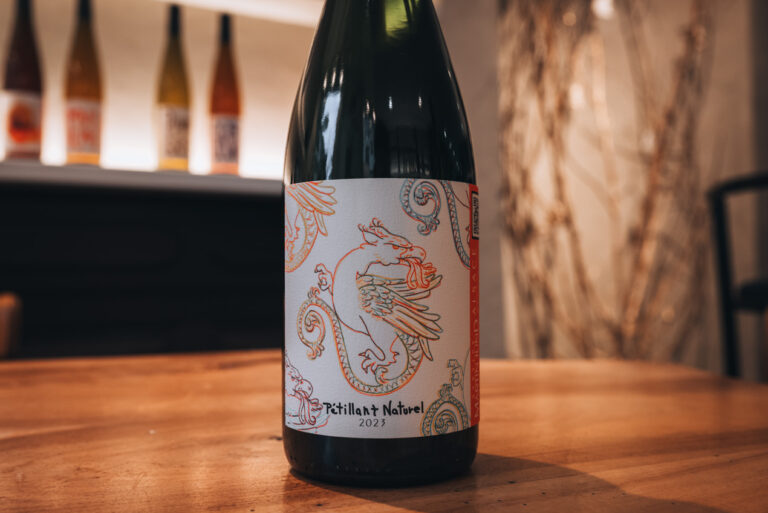 A zoom up on the label of a natural sparkling bottle of wine from Domain Martin Jund. It shows several symbols of Alsace and was designed by local artists in Colmar.
